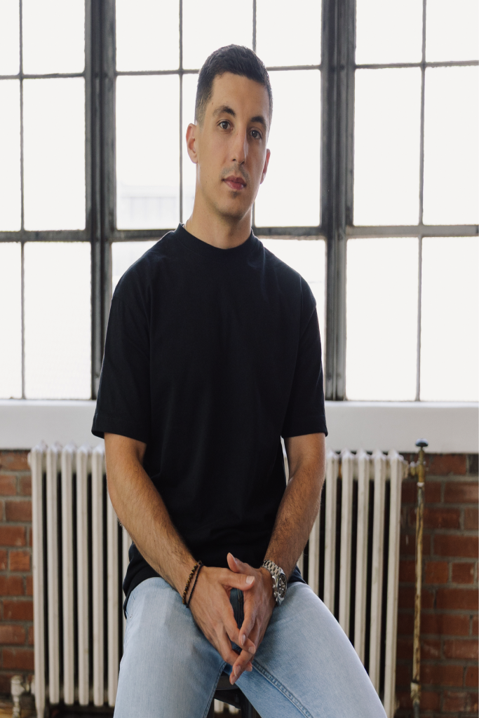 Christopher Bolliger seated in a sunlit studio.